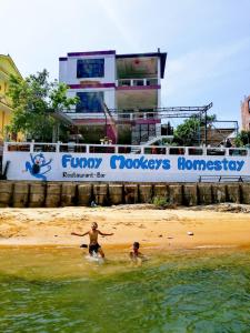 two boys playing in the water on the beach at Funny Monkeys Homestay in Phong Nha
