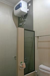 D Ajenk Boutique Villa في يوغياكارتا: حمام مع مجفف شعر على الحائط بجوار مرآة