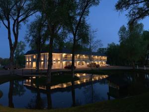 a building with lights on in front of a pond at The Gunnison Inn at Dos Rios Golf Course in Gunnison