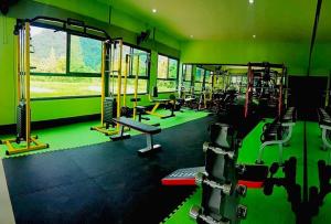 a gym with green walls and tread machines at Mg Thung Song Hotel in Thung Song