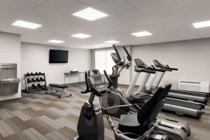 a gym with cardio machines and a flat screen tv at Wingate by Wyndham Cincinnati Blue Ash in Blue Ash