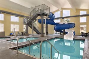 a swimming pool with a slide in a building at Ramada by Wyndham Spokane Airport in Spokane