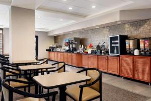 a restaurant with tables and chairs and a counter at Wingate by Wyndham Cincinnati Blue Ash in Blue Ash