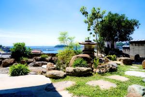 einen Garten mit Felsen und einem Brunnen in der Unterkunft そわか楼 in Fukuyama