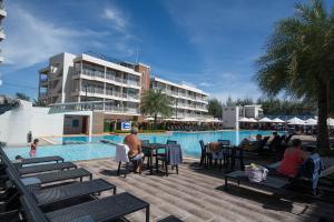 a group of people sitting around a pool at a hotel at Grandblue 411 by malai in Mae Pim