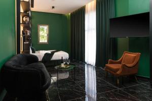 テルアビブにあるJoseph Hotel TLVの緑の壁のベッドルーム(ベッド、椅子付)