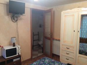 a room with a bedroom with a toilet and a television at CHAMBRE INDEPENDANTE + SANITAIRE près centre ville in Rignac - Aveyron +9 photos