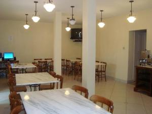 a dining room with tables and chairs and lights at Hotel Faisca in Mariana