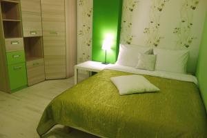 a bedroom with a bed with a green wall at Apartamenty Owocowe in Rowy