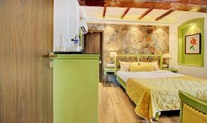 奈尼塔尔Hotel Lakeside Inn Nainital的一间带床和石墙的卧室