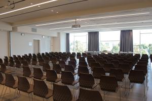 an empty lecture hall with rows of chairs at Tag Hotel in Fano