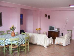 ein Esszimmer mit einem Tisch und Stühlen sowie rosafarbenen Wänden in der Unterkunft B&B L'ARCOBALENO in Palombaro
