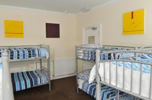 two bunk beds in a room with paintings on the wall at The Hostel in Edinburgh