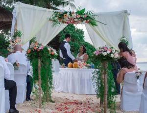 una ceremonia de boda en la playa con una novia y un novio en Le Cardinal Exclusive Resort, en Trou aux Biches