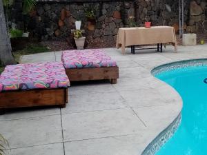 - deux lits installés à côté d'une piscine dans l'établissement Chez nous, à Pereybere