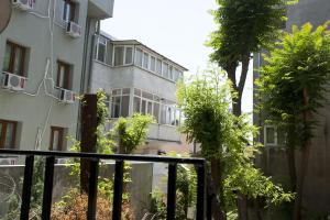 un edificio de apartamentos con árboles delante de él en Aslan Apartments, en Estambul