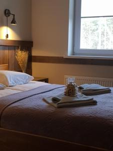 
a bed with a pillow on top of it next to a window at Sodyba Ignė in Druskininkai
