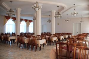 a dining room with tables and chairs and chandeliers at Pyatigorskaya Klinika Sanatorium in Pyatigorsk