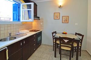 a kitchen with a sink and a table with chairs at Nikos Sea View Apartments in Adamas
