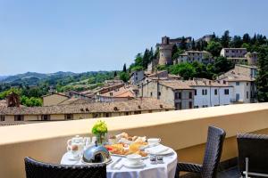 a table with a plate of food on a balcony at Grand Hotel Castrocaro Longlife Formula in Castrocaro Terme