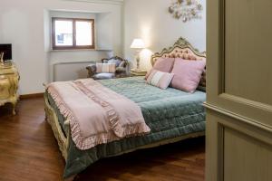 una camera da letto con un grande letto con lenzuola rosa e verdi di Appartamento Il Campo a Siena