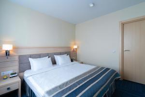 a hotel room with a large bed with two pillows at Equator Congress Hotel in Vladivostok