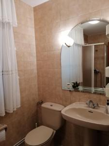 y baño con aseo, lavabo y espejo. en Casa Reibon, en Santiago de Compostela