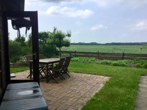 a patio with a table and chairs and a field at Alte Salzstraße 43 Ferienwohnung in Brietlingen