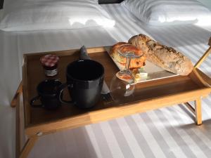 uma bandeja com comida e pão numa cama em Les cabanons de Mémé Jeannette em Port-Vendres