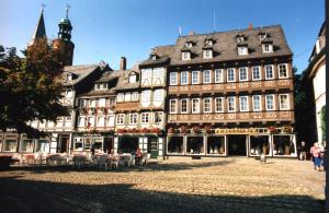 ein großes Gebäude mit Leuten, die draußen sitzen in der Unterkunft Fachwerkferienhaus Helmbrecht in Goslar