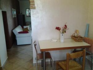 a dining room table with a vase of flowers on it at Appartamento in collina "la Perla" in Riparbella