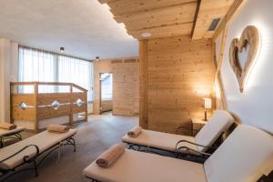 a living room with white furniture and wooden walls at Mountain Chalet Pia in La Valle +62 photos