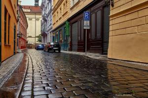 プラハにあるApart Near The Charles Bridgeの路上駐車車の石畳の通り