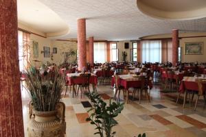ein Restaurant mit Tischen und Stühlen in einem Raum in der Unterkunft Albergo Napoleone in SantʼAmbrogio di Valpolicella