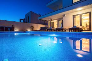 Bazén v ubytovaní Villa Nano, 4 bedrooms, jacuzzi, heated pool, sea views, pebble beach 850m alebo v jeho blízkosti