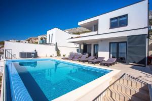 Bazén v ubytovaní Villa Nano, 4 bedrooms, jacuzzi, heated pool, sea views, pebble beach 850m alebo v jeho blízkosti