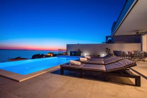 Bazén v ubytovaní Villa Nano, 4 bedrooms, jacuzzi, heated pool, sea views, pebble beach 850m alebo v jeho blízkosti