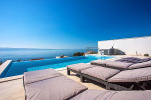 Bazén v ubytovaní Villa Nano, 4 bedrooms, jacuzzi, heated pool, sea views, pebble beach 850m alebo v jeho blízkosti