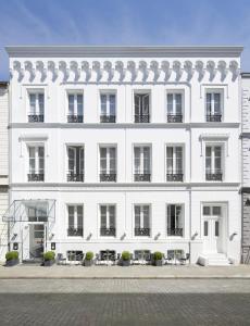 a white building with tables and chairs in front of it at Aussen Alster Hotel in Hamburg