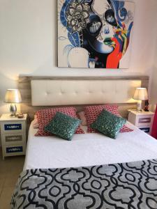 1 dormitorio con 1 cama con una pintura en la pared en Costa Adeje Mareverde Apartment en Adeje