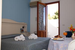 a bedroom with two beds and a table with a plate of food at Camping Village La Pineta in San Vito lo Capo +53 photos