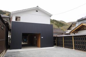 a black and white house with a garage at 北房まちの駅 AZAE ドリトミー azae in Maniwa