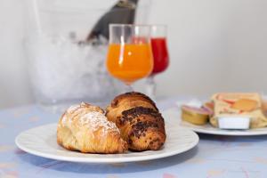 two plates of pastries on a table with a glass of orange juice at Camping Village La Pineta in San Vito lo Capo