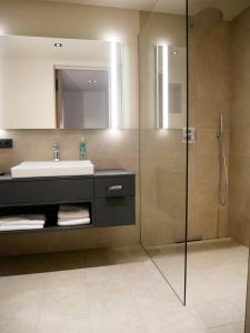 a bathroom with a sink and a shower at Best Western Premier Hotel Rebstock in Würzburg