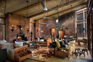a living room filled with furniture and a brick wall at Marataba Safari Lodge in Hartbeestfontein