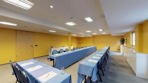 ein Klassenzimmer mit blauen Tischen und Stühlen und gelben Wänden in der Unterkunft Hotel-Restaurant Stand'Inn in Foetz