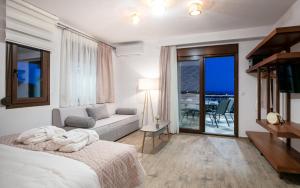 a bedroom with a bed and a couch and a balcony at DIKAP Luxury Aparts in Limenaria