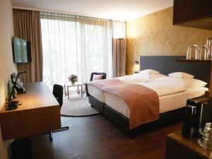 a hotel room with a bed and a desk at Best Western Premier Hotel Rebstock in Würzburg
