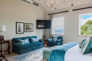 a bedroom with two blue chairs and a bed at Tintswalo Boulders in Simonʼs Town