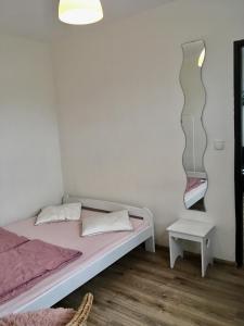a small bedroom with a bed and a table at Latarnik in Karwia